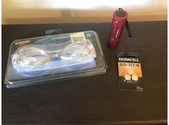 Assorted Lot Featuring New Speedo Brand Swimming Goggles, LED Harbor Freight Flashlight, And Pack Of Small Bat