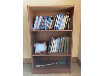 Wooden Bookshelf With A Collection Of Books And To Fly Swatters