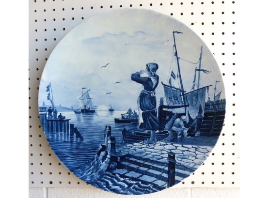 A Hand Painted Delft Charger Depicting Lady At Fishing Port With Boats, 19th Century. Signed V & B Over An M.