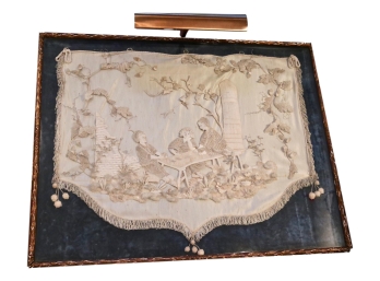Antique Silk Framed Art With Embroidered Design And Overhead Indirect Lighting
