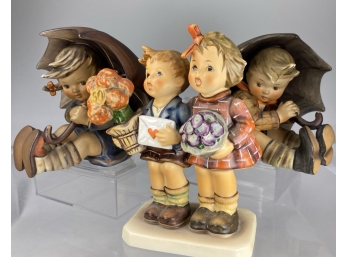 Three M.J. Hummel Figurines Two. Boys With Umbrellas And A Pair Of Children With Valentine And Flowers
