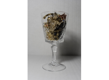 A Glass With Class A Crystal Glass Filled With Several Pieces Of Jewelry