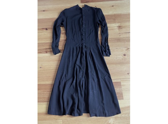 Black Crepe Dress With Long Sleeves And 2 Covered Buttons And Self Cuff.
