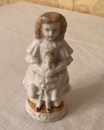 Porcelain Child Figurine Holding Doll