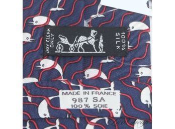 AUTHENTIC AND NEAR MINT HERMES MADE IN FRANCE MENS SILK TIE IN NAVY WITH RED WAVE AND DOLPHINS 987 SA