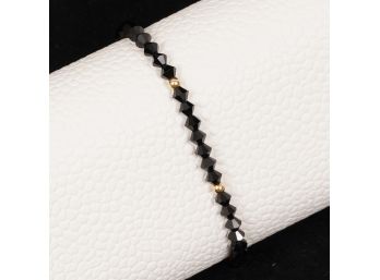 A GORGEOUS BLACK FACETED CRYSTAL BEAD BRACELET WITH TESTED 14K YELLOW GOLD BALLS AND CLASP