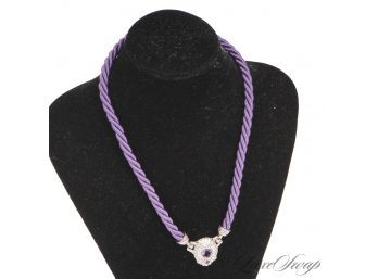 AN ANONYMOUS BUT BEAUTIFUL .925 STERLING SILVER CORDED CHARM WITH PURPLE CRYSTAL ON A BRAIDED SILK NECKLACE
