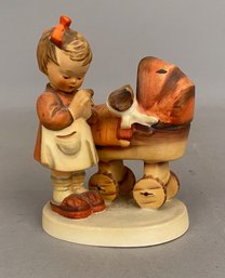 Goebel Hummel Figurine Of A Child Praying Next To A Baby Doll In A Pram