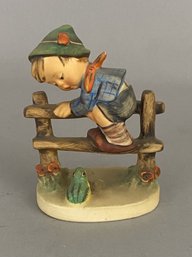 Goebel Hummel Figurine Of A Boy Climbing Over A Fence With A Frog