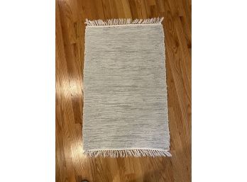 A Hand Woven Scatter Rug With Fringe
