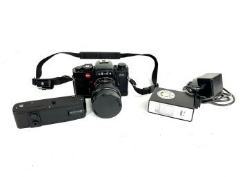 A Leitz Leica R4 35mm Film Camera, Elmarit-R Lens, A Winder And Braun F 110 Flash