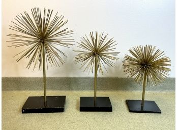 A Trio Of Gold Painted Spiked Metal Orbs On Stands