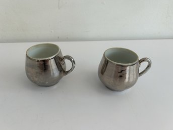 A Pair Of Glazed Silver Coffee Cups