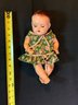 Vintage Composition Baby Doll In A Green Flowered Dress