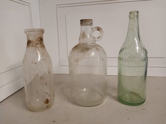 3 Antique Glass Bottles, One Half Gallon, One Milk Bottle, One In Pale Green