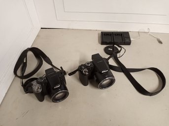 Two Nikon Brand Cameras. Both Work. Includes Kastar LTD2 USB Charger. One Battery.