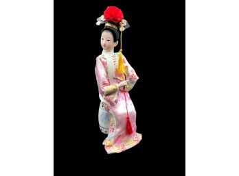 Vintage China Doll In Traditional Costume Sitting On Ceramic Stool And Black Platform