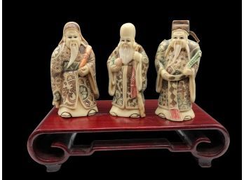 Three Japanese Netsuke Figures On Carved Wooden Platform