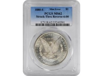 1880-S Morgan Silver Dollar Struck Thru Reverse 6:00 PCGS MS-62. Semi Proof Like Mirror Surfaces.