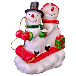 Two Snowmen Riding A Sled Sledding