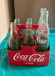 Various Glass Coke Bottles In 6 Pack Holder