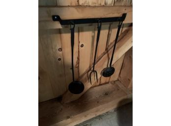 3 Primitive Iron Cooking Tools On A Cast Iron Rack