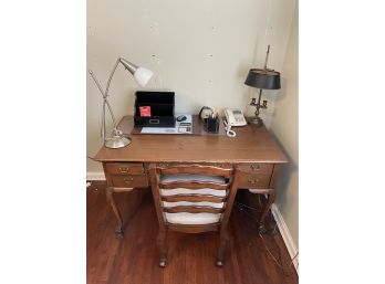Solid Claw Foot Wood Table With 5 Drawers  Assorted Office Supplies, Two Lamps, And A Chair
