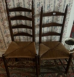 2 Similar Antique Ladder Back Rush Seated Chair One With Hooked Seat Pad And Hand Knitted Throw